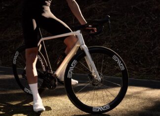 Vélo route Colnago C72 : caractéristiques et prix Cycliste arrêté en bord de route avec le vélo route Colnago C72 coloris HFWS blanc nacré, roues ENVE SES 4.5