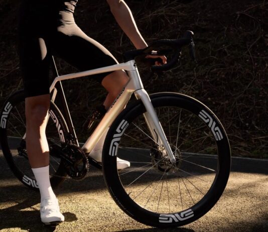 Vélo route Colnago C72 : caractéristiques et prix Cycliste arrêté en bord de route avec le vélo route Colnago C72 coloris HFWS blanc nacré, roues ENVE SES 4.5